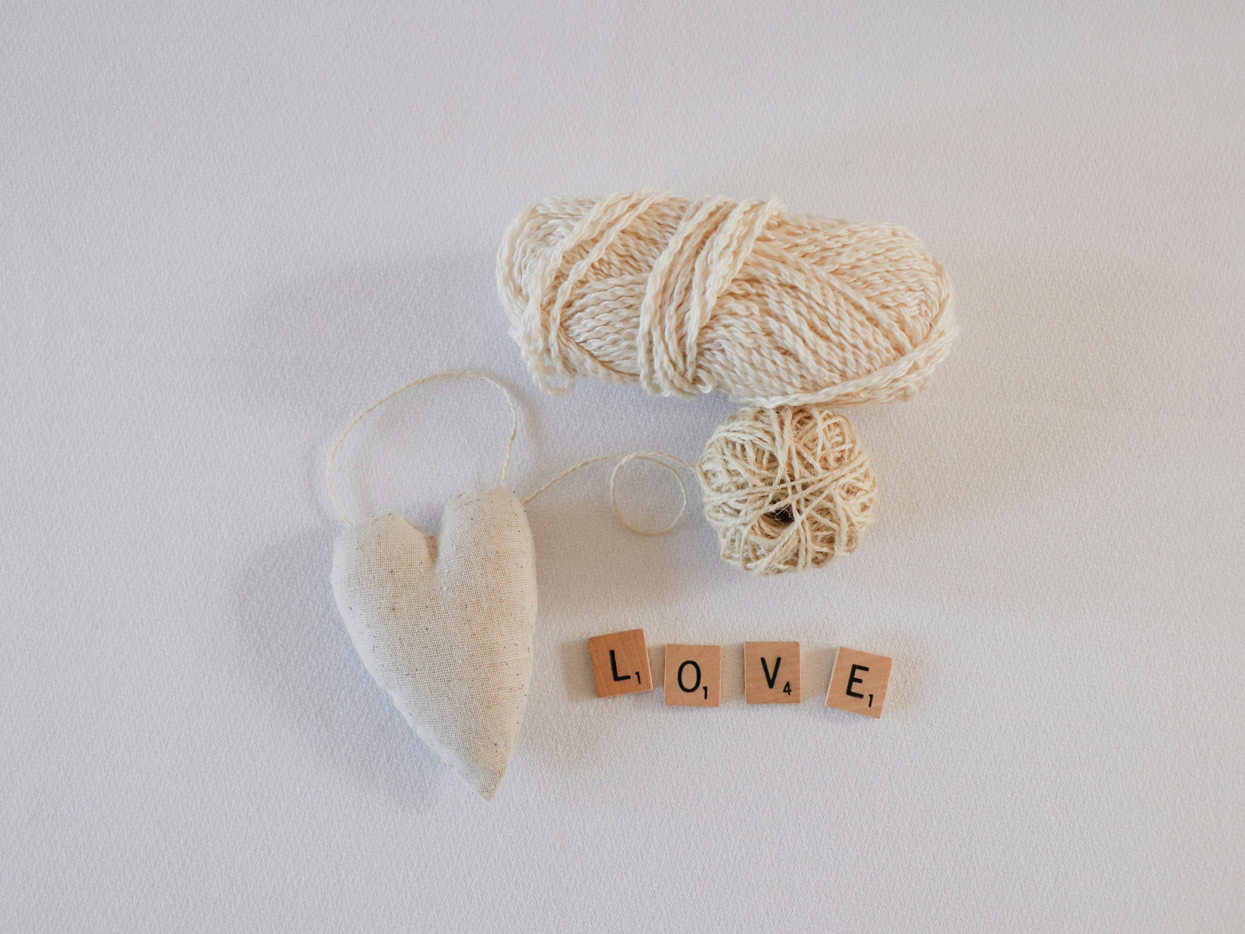 white yarns beside white heart accessory